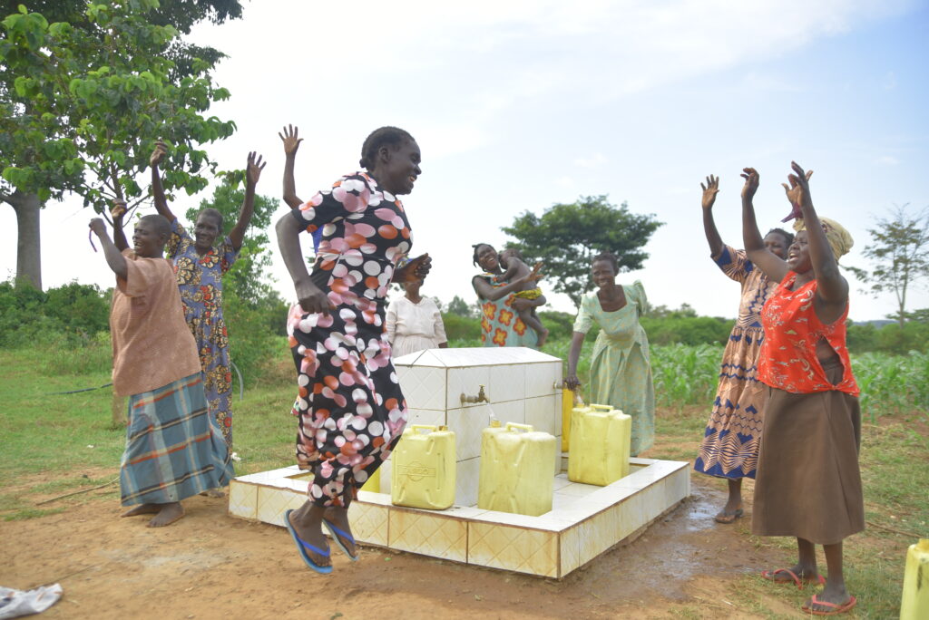 Community members celebrating at a community water source